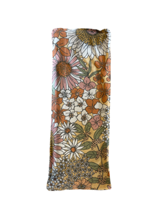 A rectangular lavender pillow with a vibrant daisy print featuring orange, yellow, white or pink flowers.