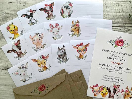 Set of stationery items with farm animal illustrations & florals on a wooden surface