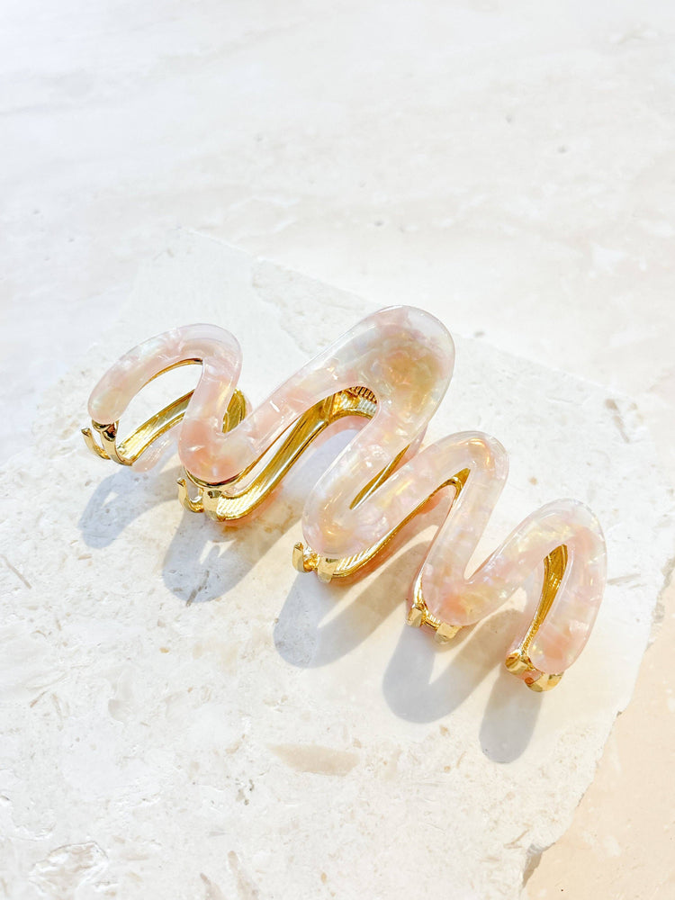 A range of Wave Acrylic Metal Claw Clips by Angels Whisper Accessories, displayed in various colours. The clips feature a stylish wavy design with a sturdy metal clasp.