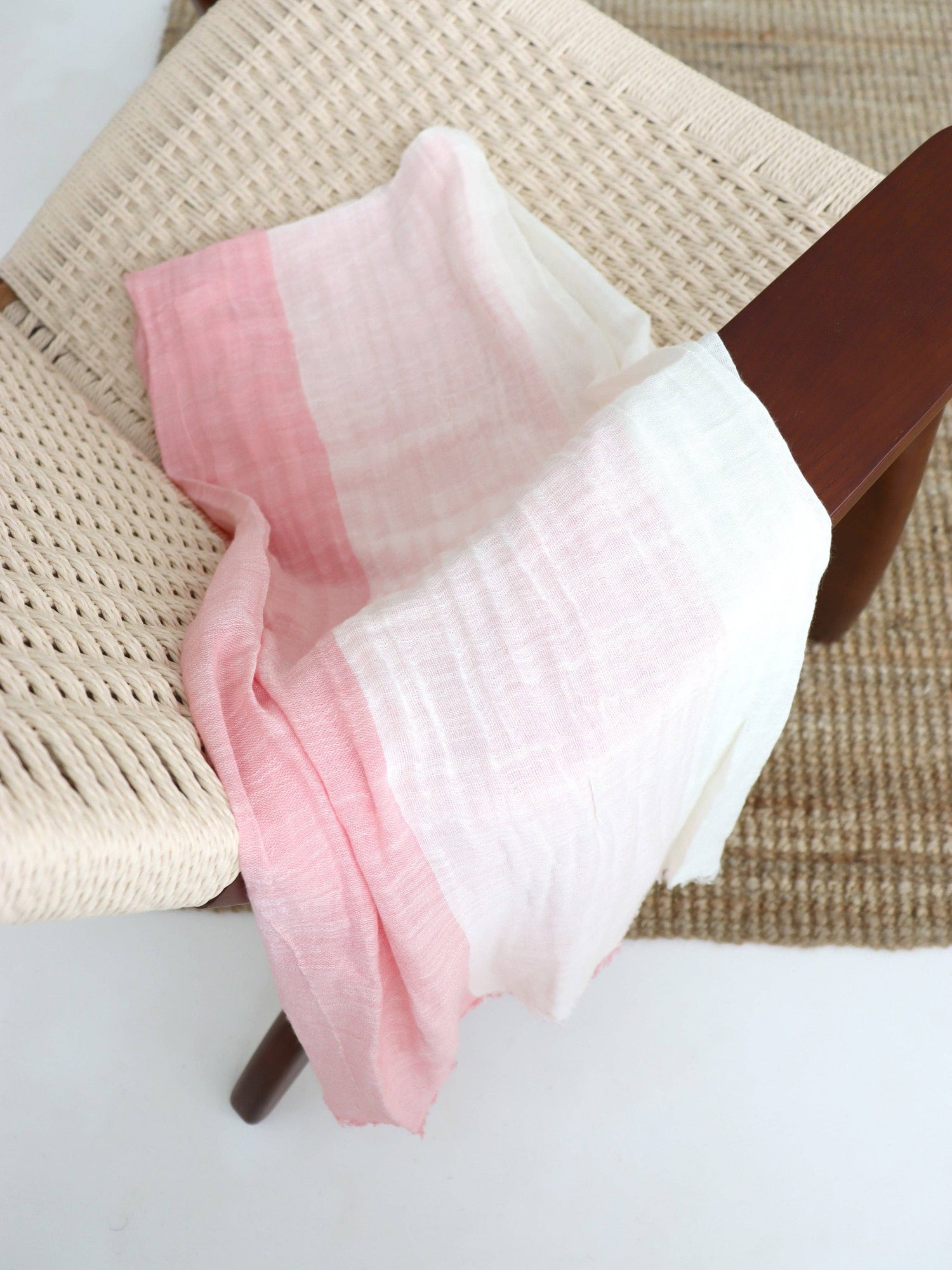 A two-tone pink and white cotton lightweight scarf.