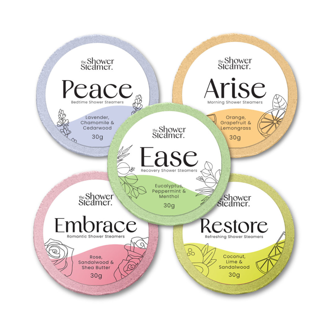 Shower Steamer Treat Pack containing five round shower steam packets. The Shower Steamers are arranged in a circle on a white background. The packets are labeled Peace, Arise, Ease, Embrace, and Restore, with different pastel colors and botanical illustrations.