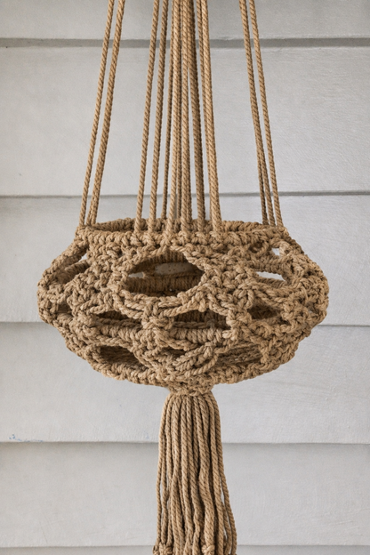 Handmade taupe macrame plant hanger, angled view.