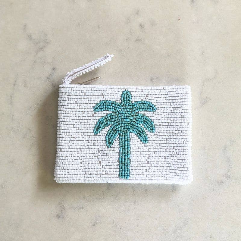 Hand beaded coin purse with palm tree design on a marble surface