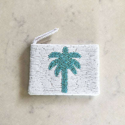 Hand beaded coin purse with palm tree design on a marble surface
