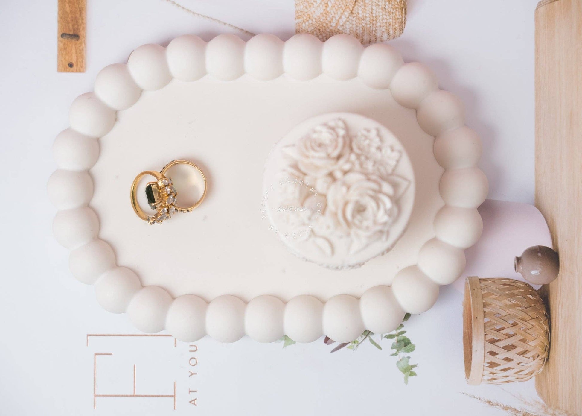 Oval Cream white bubble trinket tray holding gold rings and jewelry dish, surrounded by neutral-toned decor items.