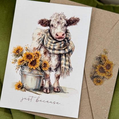 Card with a cow illustration wearing a scarf, surrounded by sunflowers, on a green background.