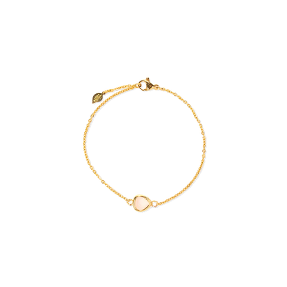A delicate gold chain bracelet featuring a small, pale pink glass stone inlay, shown on a plain white background.