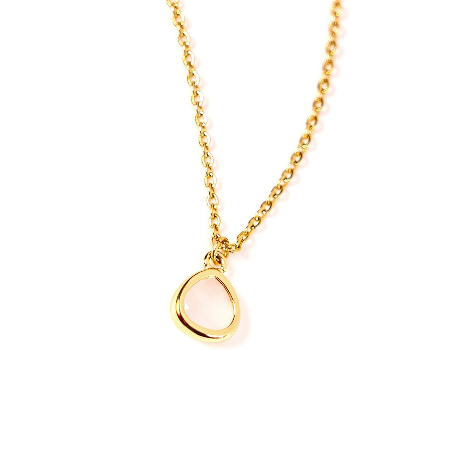 A delicate gold chain necklace with an open, teardrop-shaped pink pendant, photographed against a seamless white background.