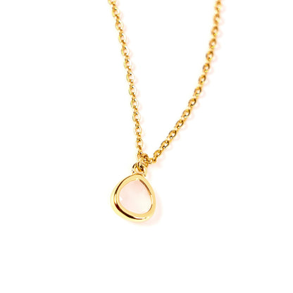 A delicate gold chain necklace with an open, teardrop-shaped pink pendant, photographed against a seamless white background.