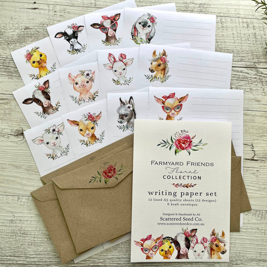 Writing paper set with farm animal illustrations and matching envelopes on a wooden surface.