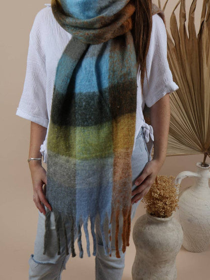 Fluffy oversized scarf in a cozy mix of browns, blue, green and dark grey tones, featuring a soft textured pattern perfect for winter warmth.
