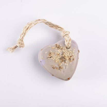 Heart-shaped lavender soap with a soft purple hue, threaded with natural jute and infused with dried laveder buds, giving a calming, handmade feel.