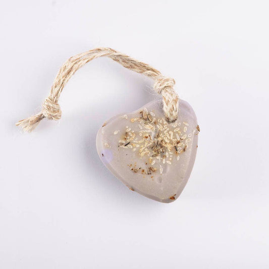 Heart-shaped lavender soap with a soft purple hue, threaded with natural jute and infused with dried laveder buds, giving a calming, handmade feel.