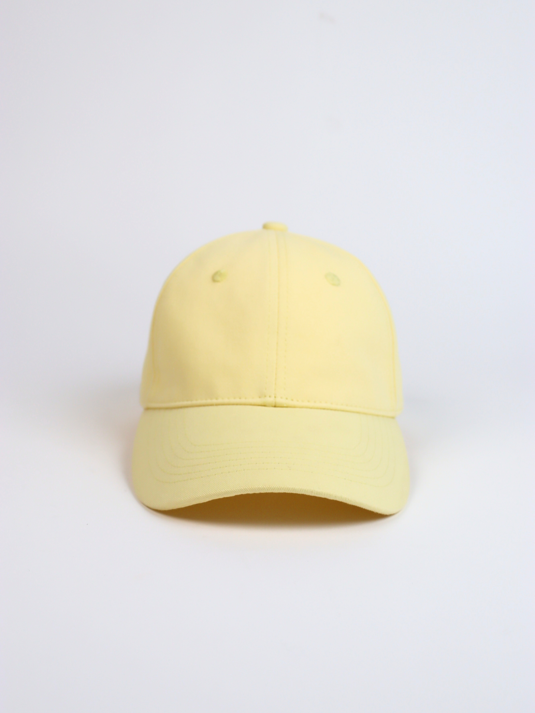 Yellow  adjustable baseball cap on a light gray background