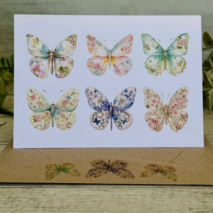 Card  and envelope with floral butterfly illustrations on a wooden surface