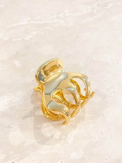 A small gold claw clip with a simple, elegant design, ideal for securing small sections of hair.