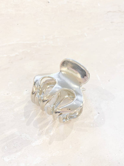 A small silver claw clip with a simple, elegant design, ideal for securing small sections of hair.
