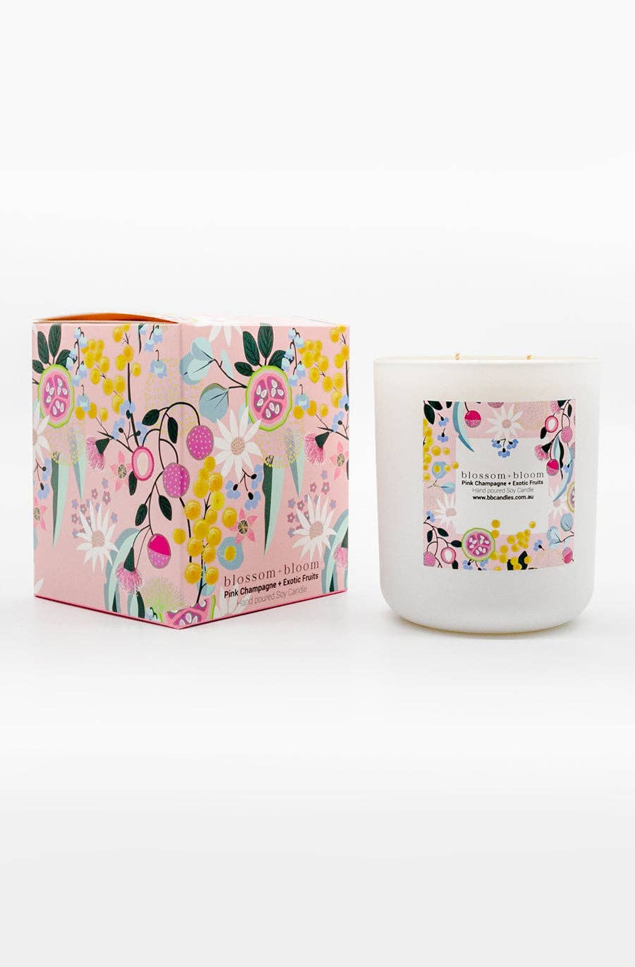A white candle labelled blossom + bloom with packaging featuring colorful floral patterns. The scent is Pink Champagne + Exotic Fruits.