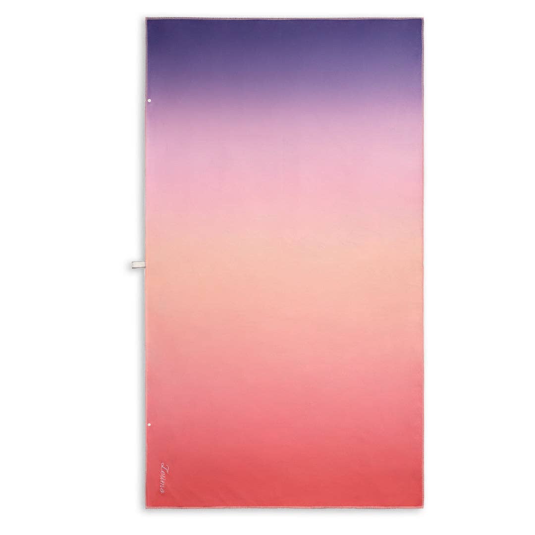 Sand free towel with a lagoon sunset inspired design. A gradient from soft purple haze to rich magenta, fading into bold red, capturing a shift from cool to warm tones.
