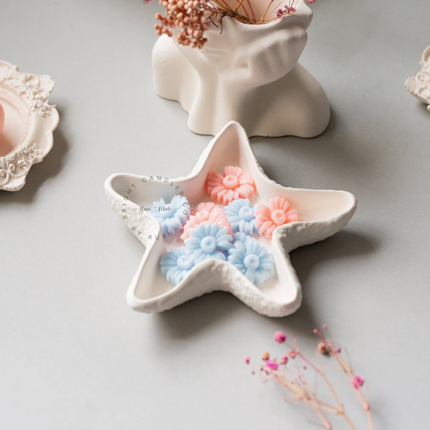 Pink and blue flower-shaped wax melts displayed in a Star Trinket Tray, creating a charming and decorative arrangement.