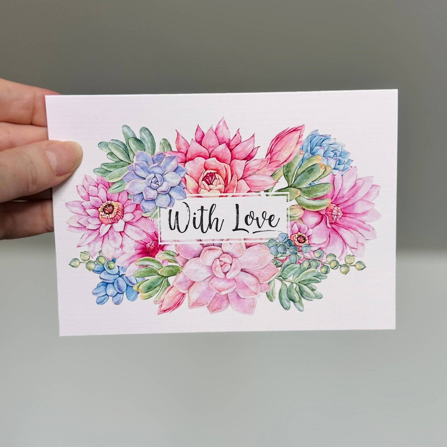 Greeting card featuring vibrant, richly colored succulents with the words 'With Love' on the front, printed on ivory textured card stock.