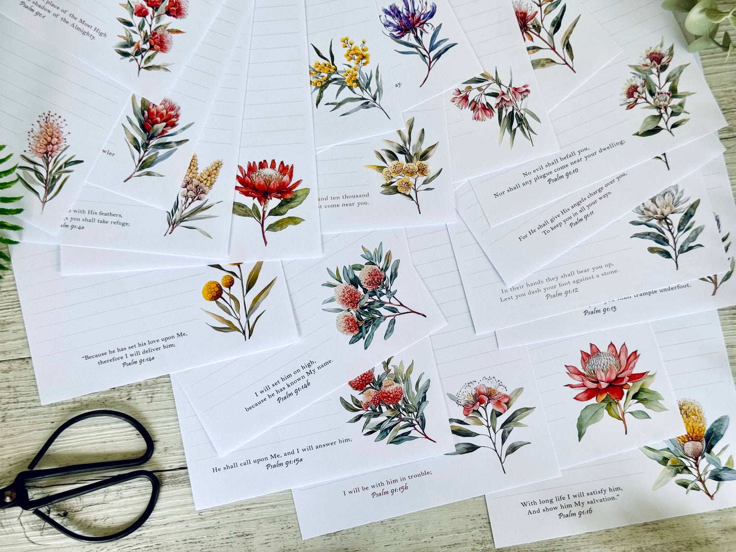 Set of greeting cards with native floral designs on a wooden surface.